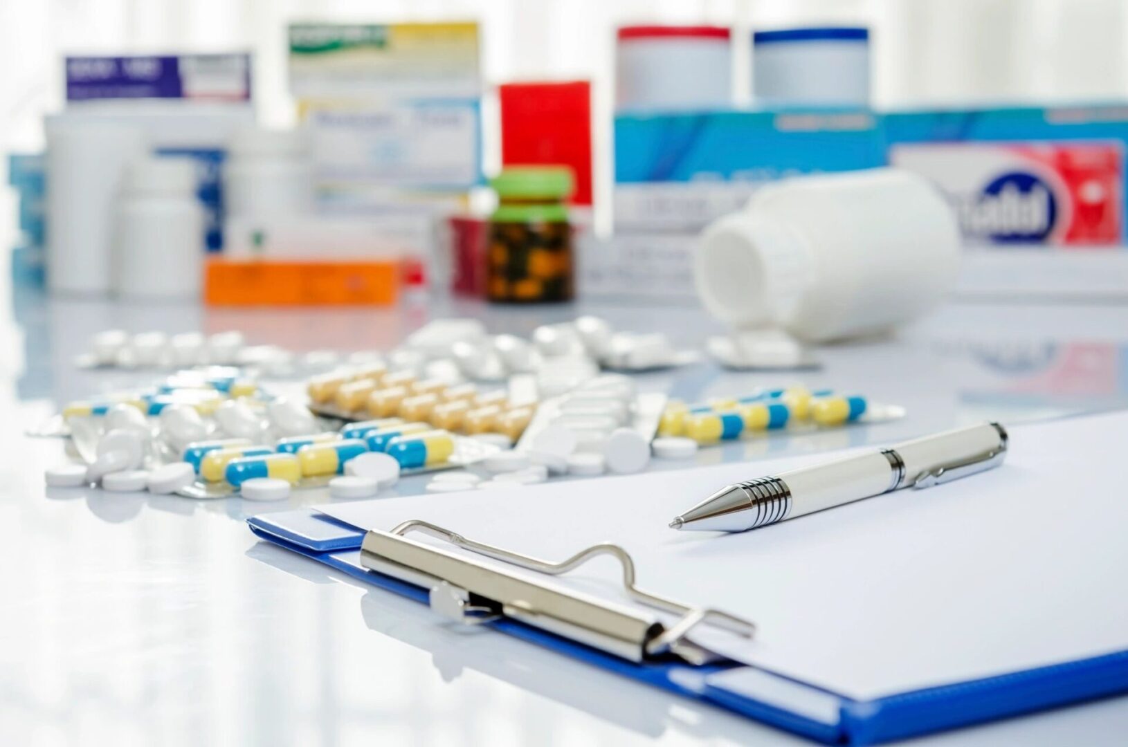 A table with many different pills and some pens