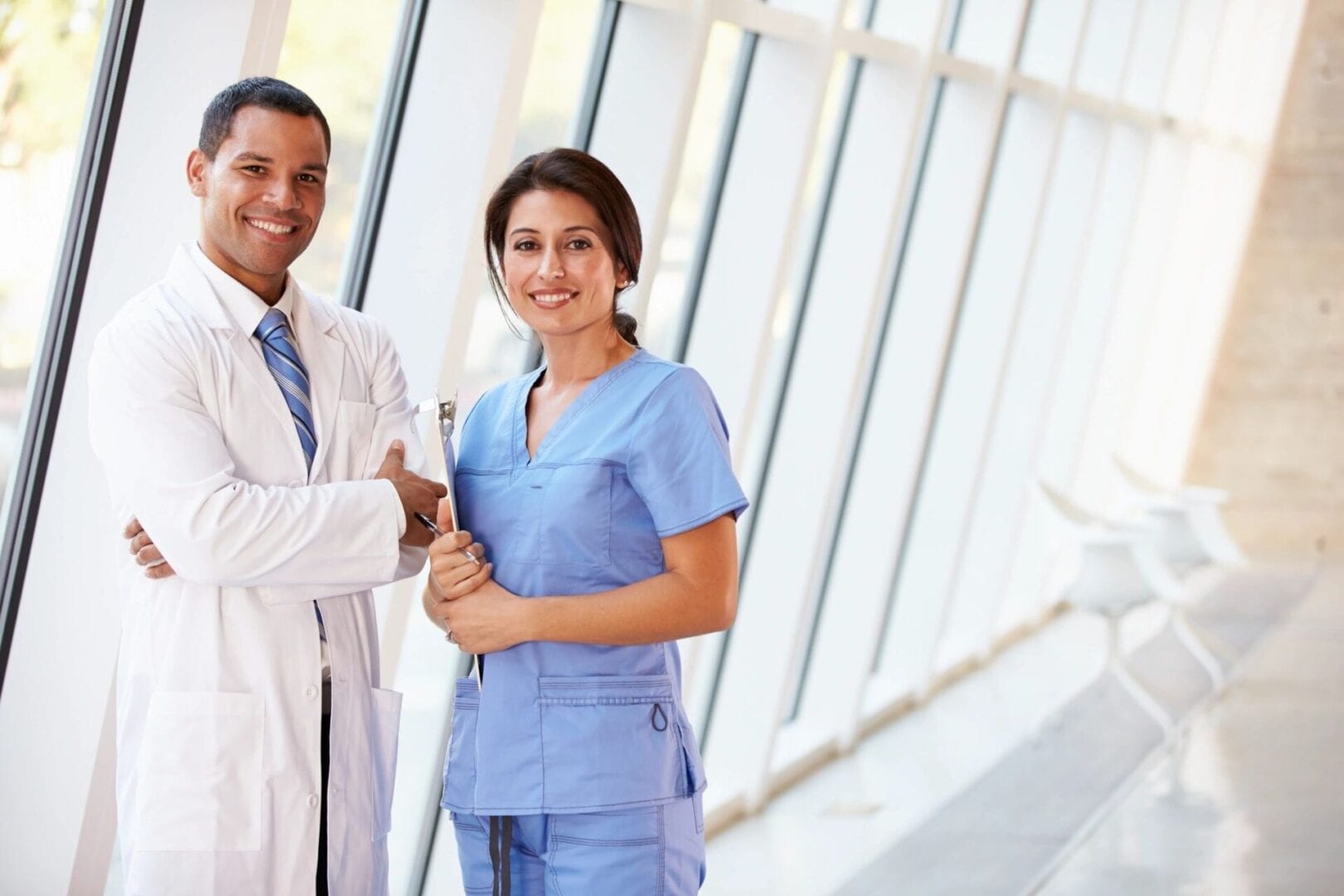 A doctor and nurse are smiling for the camera.